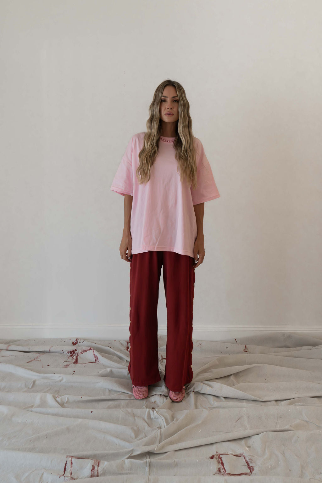 Model wears a relaxed fit oversized tshirt in a baby pink block colour made from 100% organic cotton