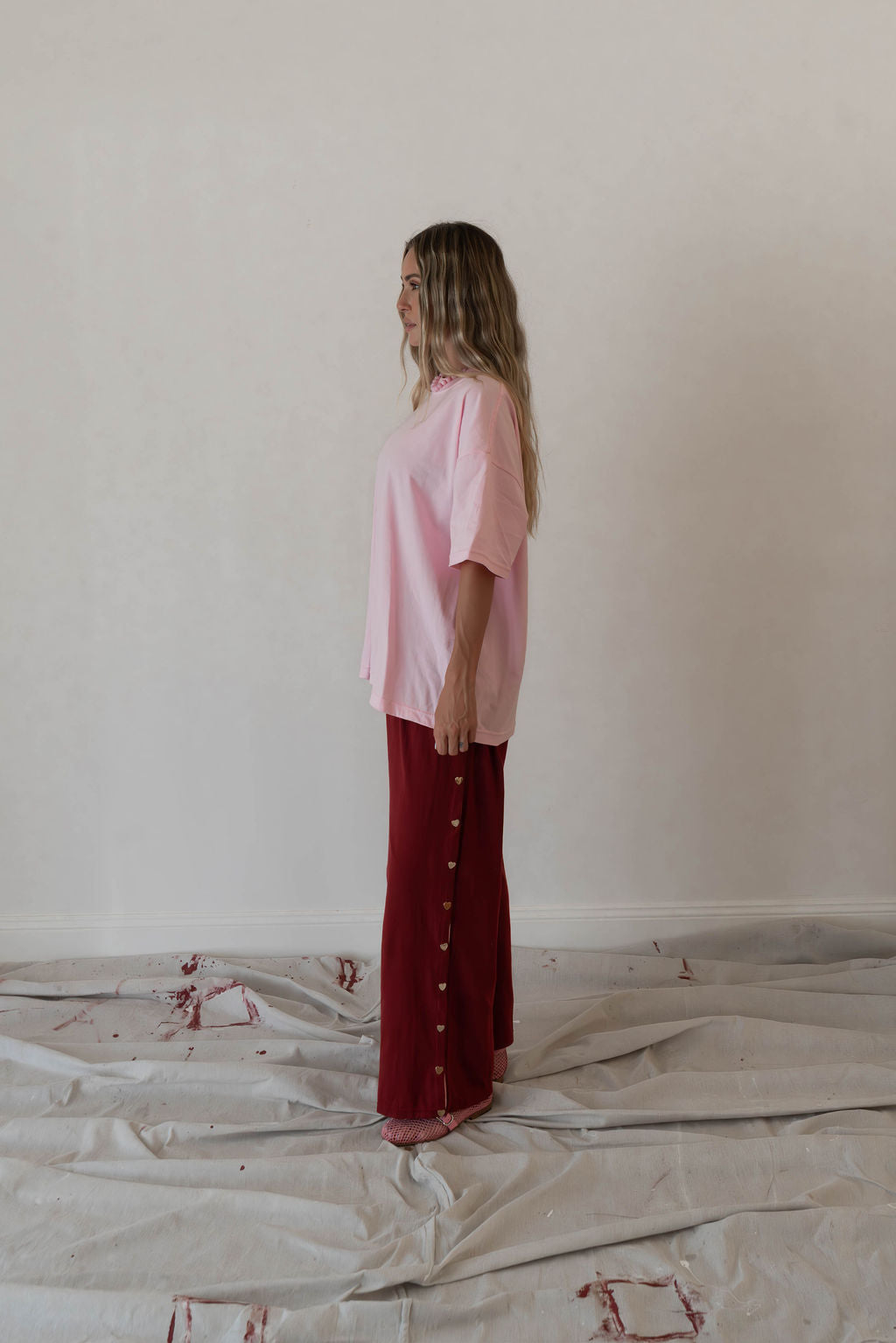 Model wears a relaxed fit oversized tshirt in a baby pink block colour made from 100% organic cotton