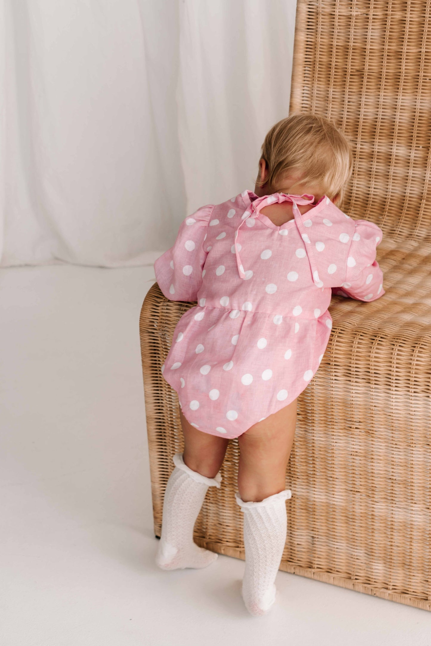 baby toddler romper in the cutest polkadot print hot pink with white dots a v neck front a adjustable back with ties long sleeves with elastic cuffs