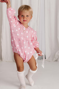 baby toddler romper in the cutest polkadot print hot pink with white dots a v neck front a adjustable back with ties long sleeves with elastic cuffs