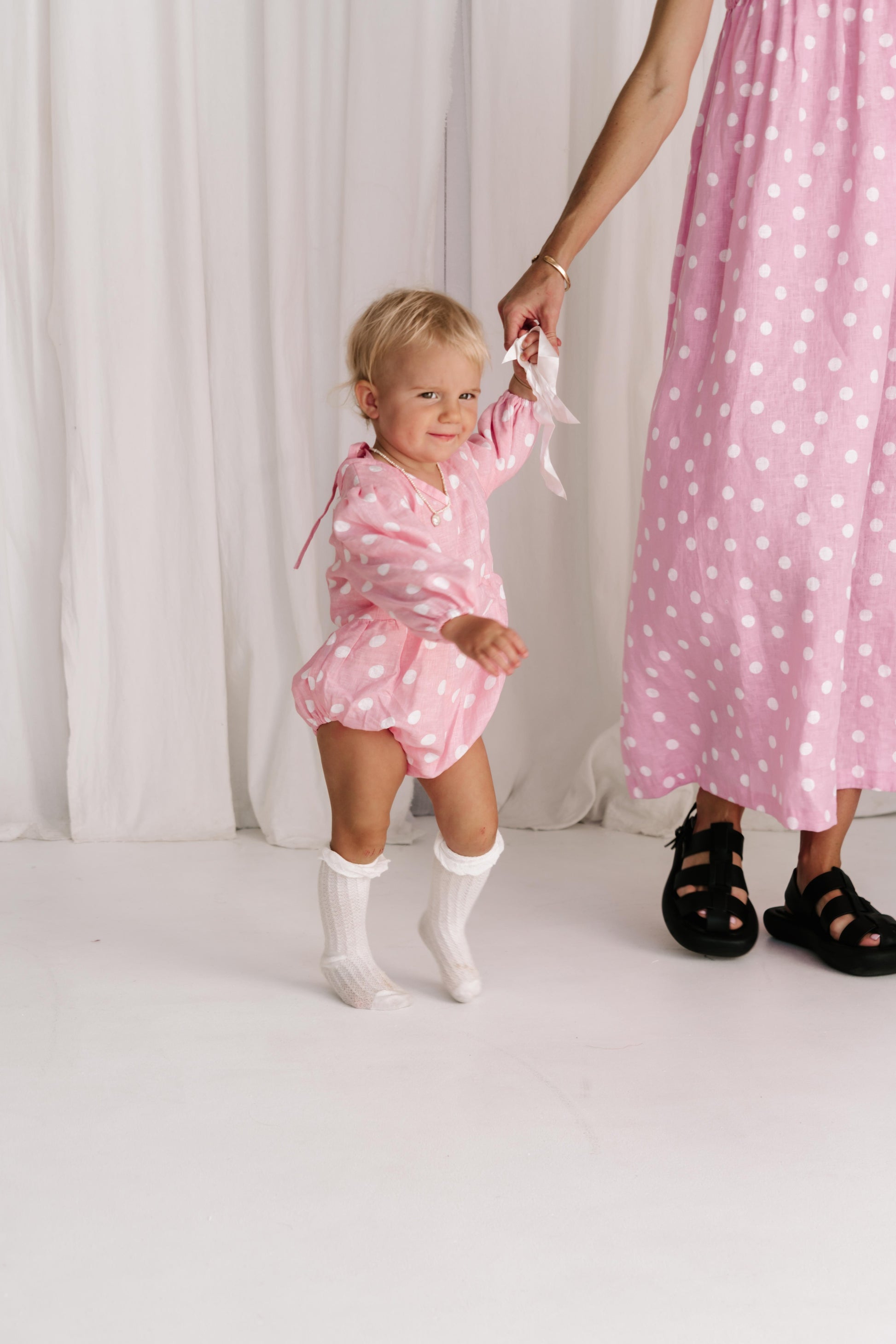 baby toddler romper in the cutest polkadot print hot pink with white dots a v neck front a adjustable back with ties long sleeves with elastic cuffs