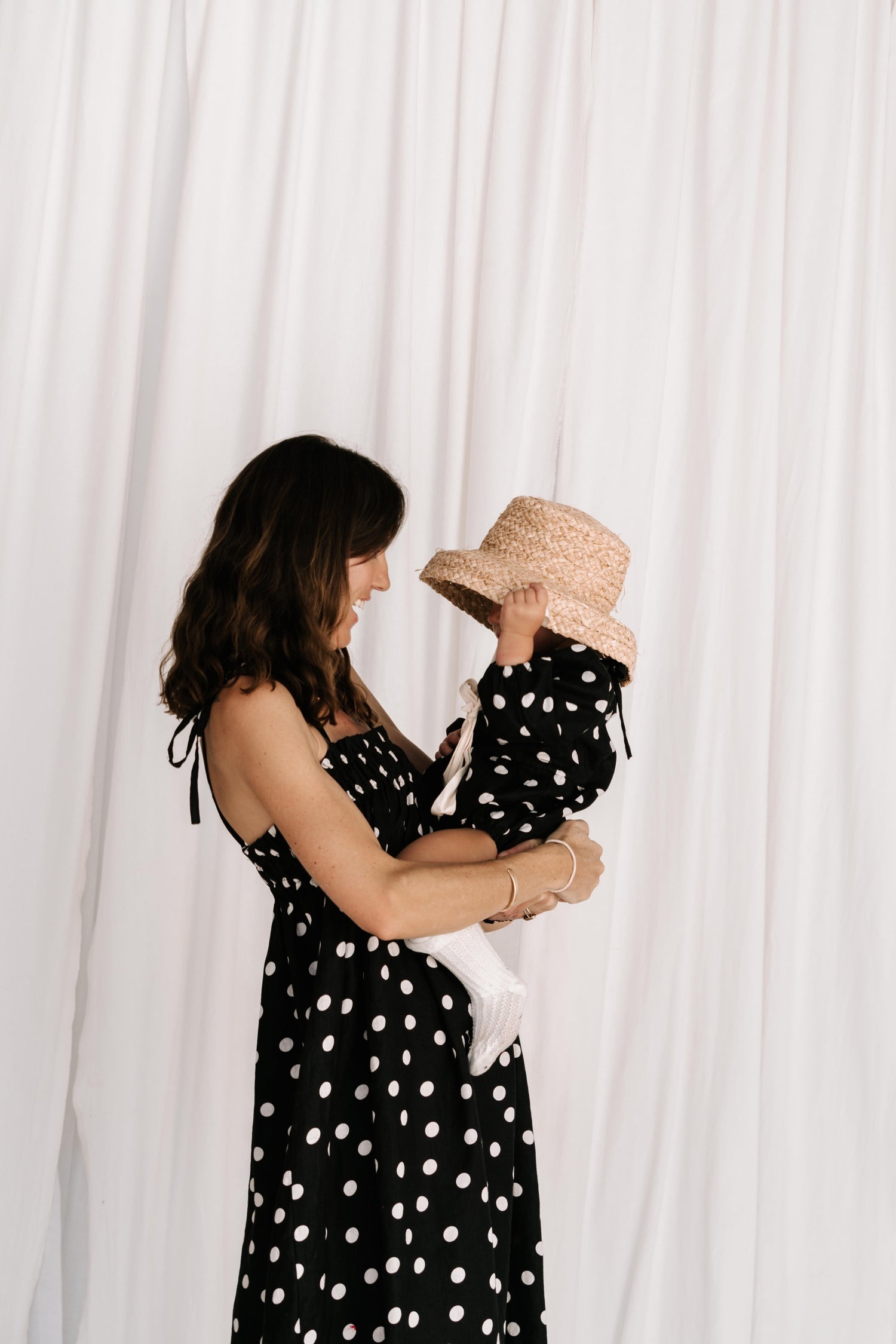 baby toddler romper in the cutest polkadot print in black and white colour with white dots a v neck front a adjustable back with ties long sleeves with elastic cuffs