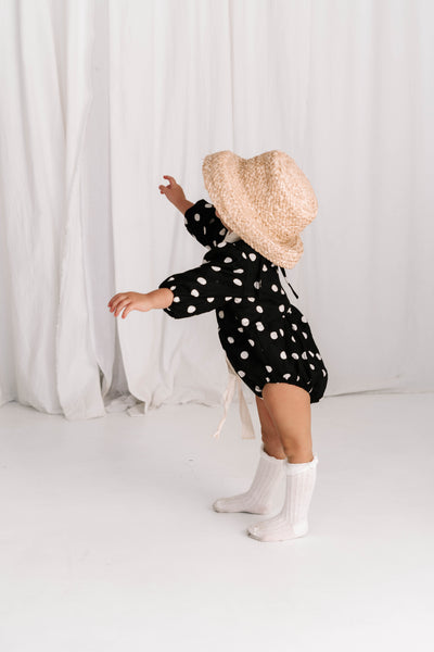 baby toddler romper in the cutest polkadot print in black and white colour with white dots a v neck front a adjustable back with ties long sleeves with elastic cuffs