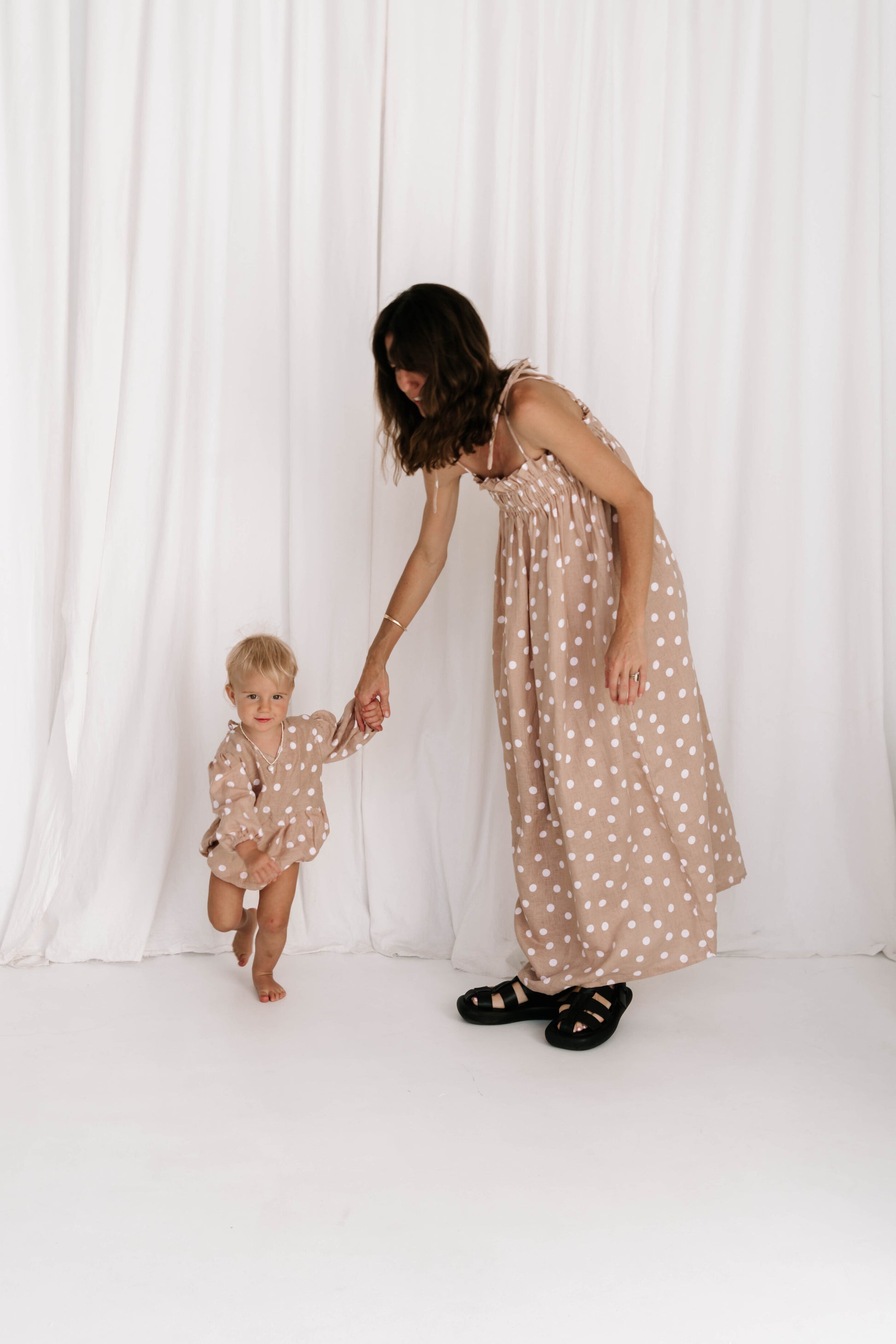 baby toddler romper in the cutest polkadot print nougat beige colour with white dots a v neck front a adjustable back with ties long sleeves with elastic cuffs